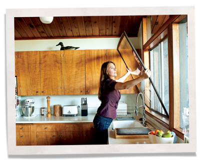 妇女安装内窗插入器，以减少噪音和能源效率