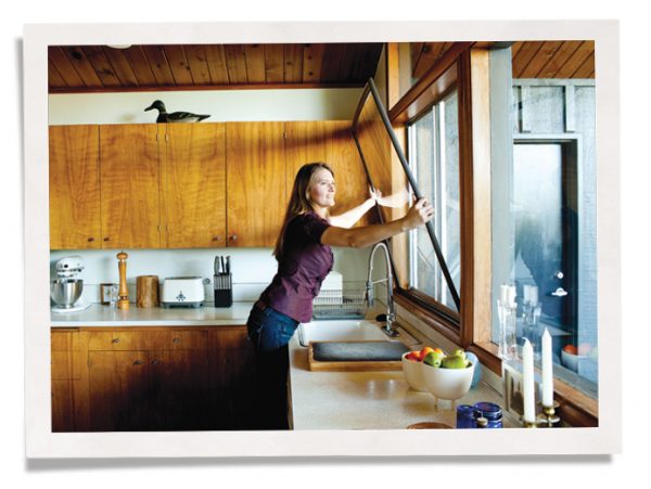 女人在厨房窗户上安装冬季插入物