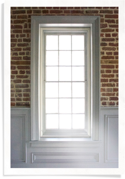 高大，垂直的窗户上有旧的红砖和白色镶板，并在框架内插入窗户。
