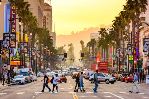 行人穿越洛杉矶的一条繁忙而嘈杂的街道