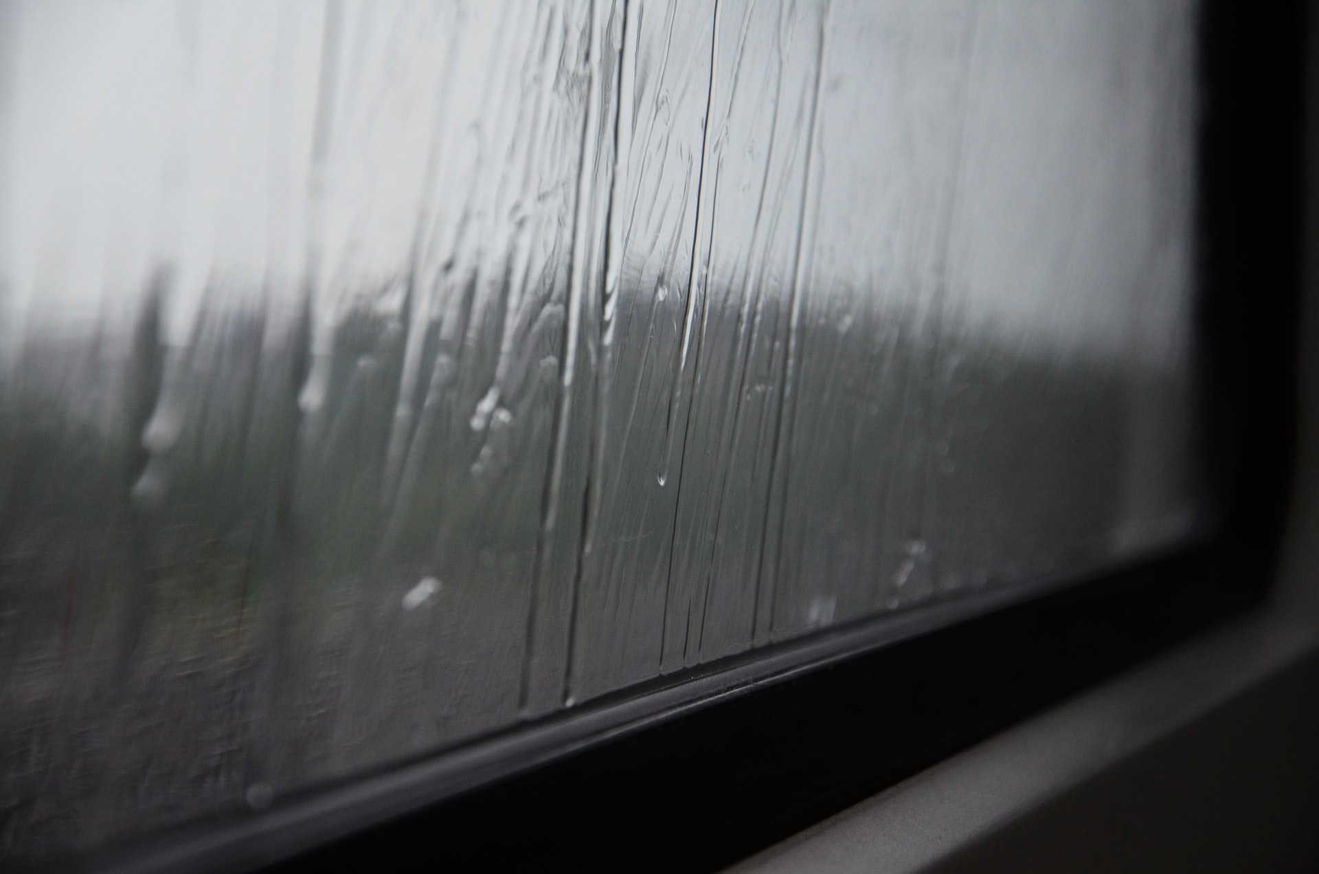 雨滴从窗户底部滴下的特写镜头。
