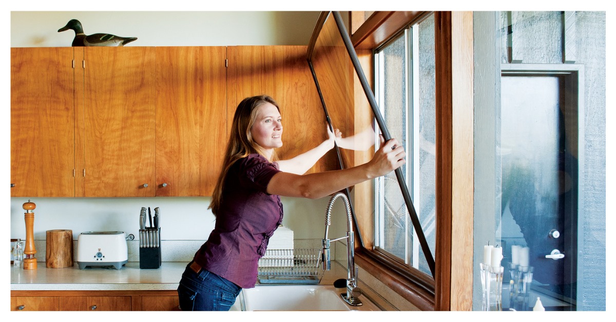 安装窗口的女人插入她的厨房窗口。